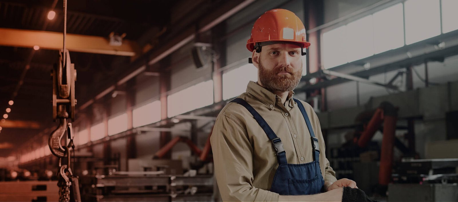 Engineer wearing an orange hard hat in an industrial workshop